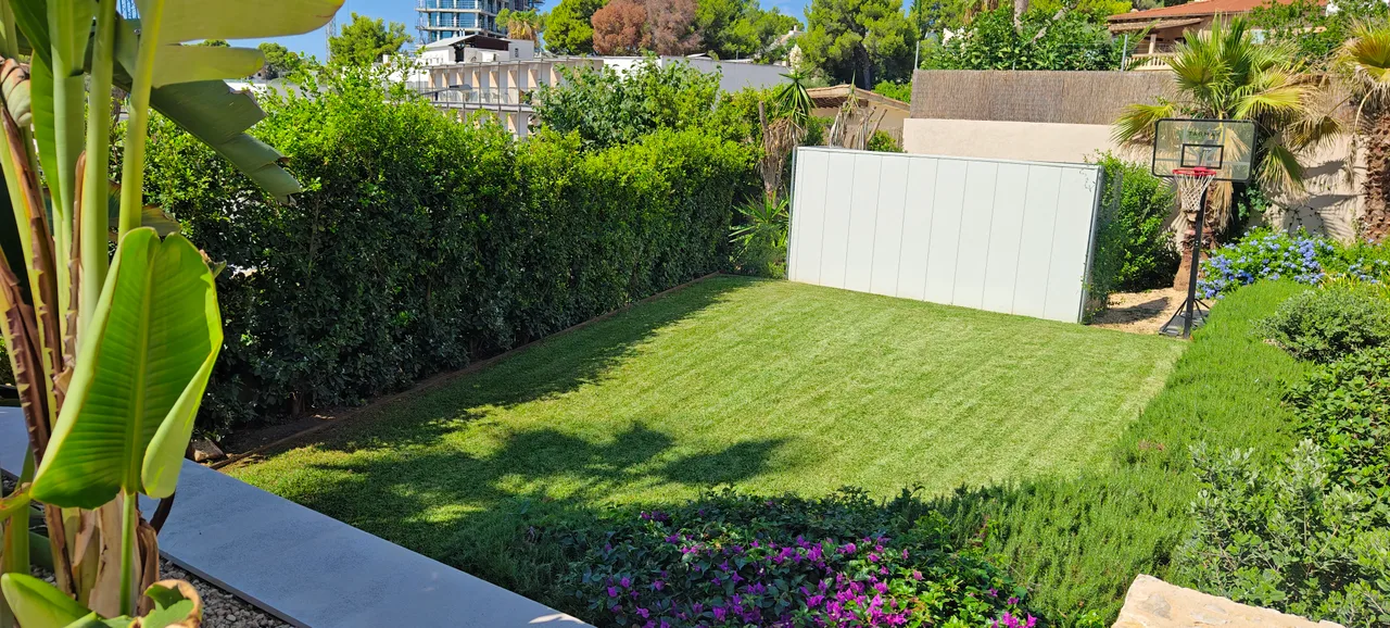 Césped y parterres de un jardín mantenido por VJARDINERS