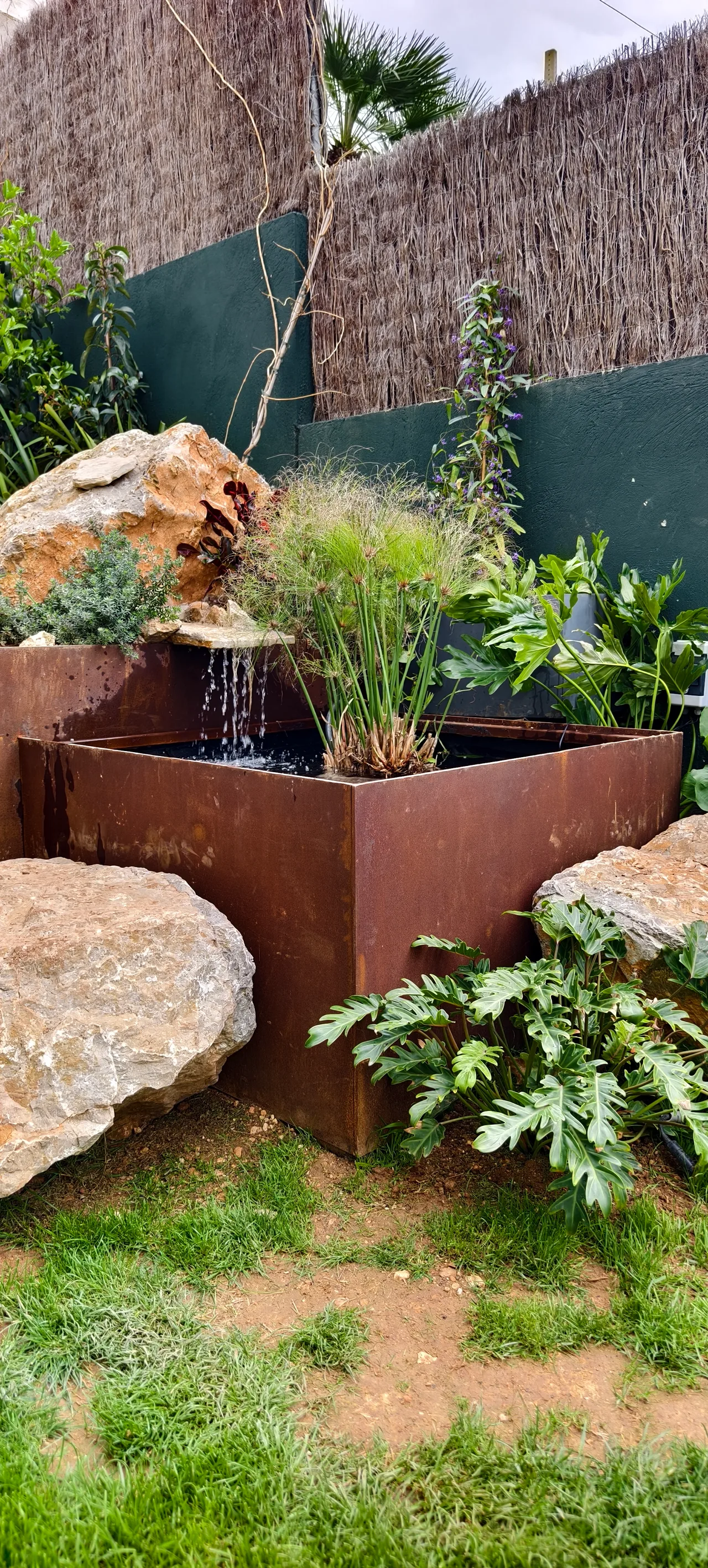 Jardinera de acero corten con lamina de agua y gramineas