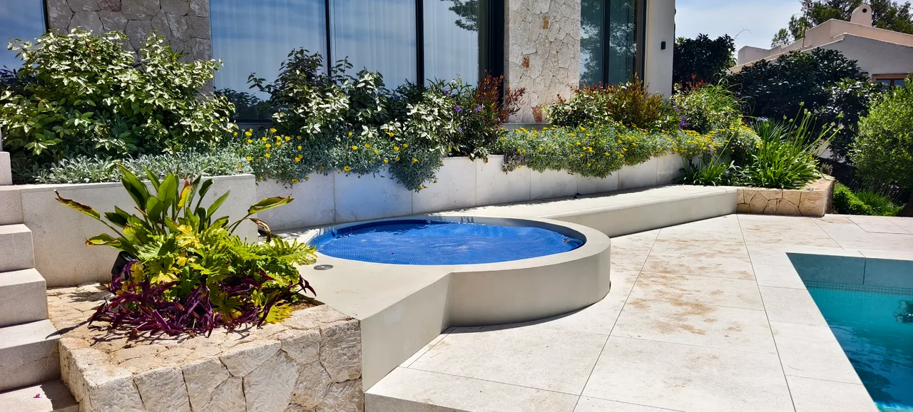 Piscina y banera de hidromasaje integradas en una terraza de piedra